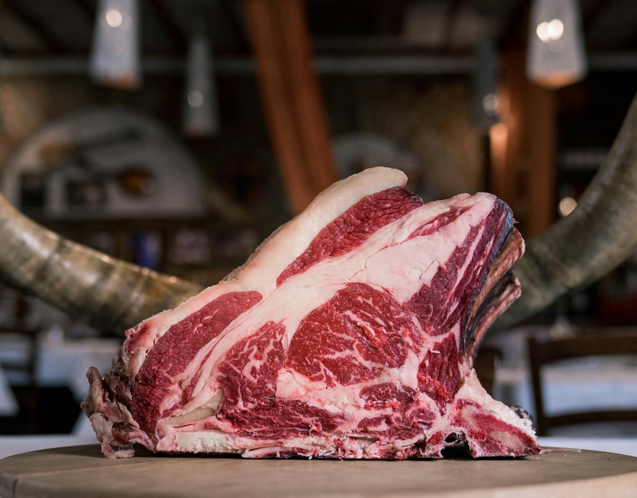 High-quality marbled beef rib displayed on a rustic wooden table, showcasing its raw texture and rich colors.